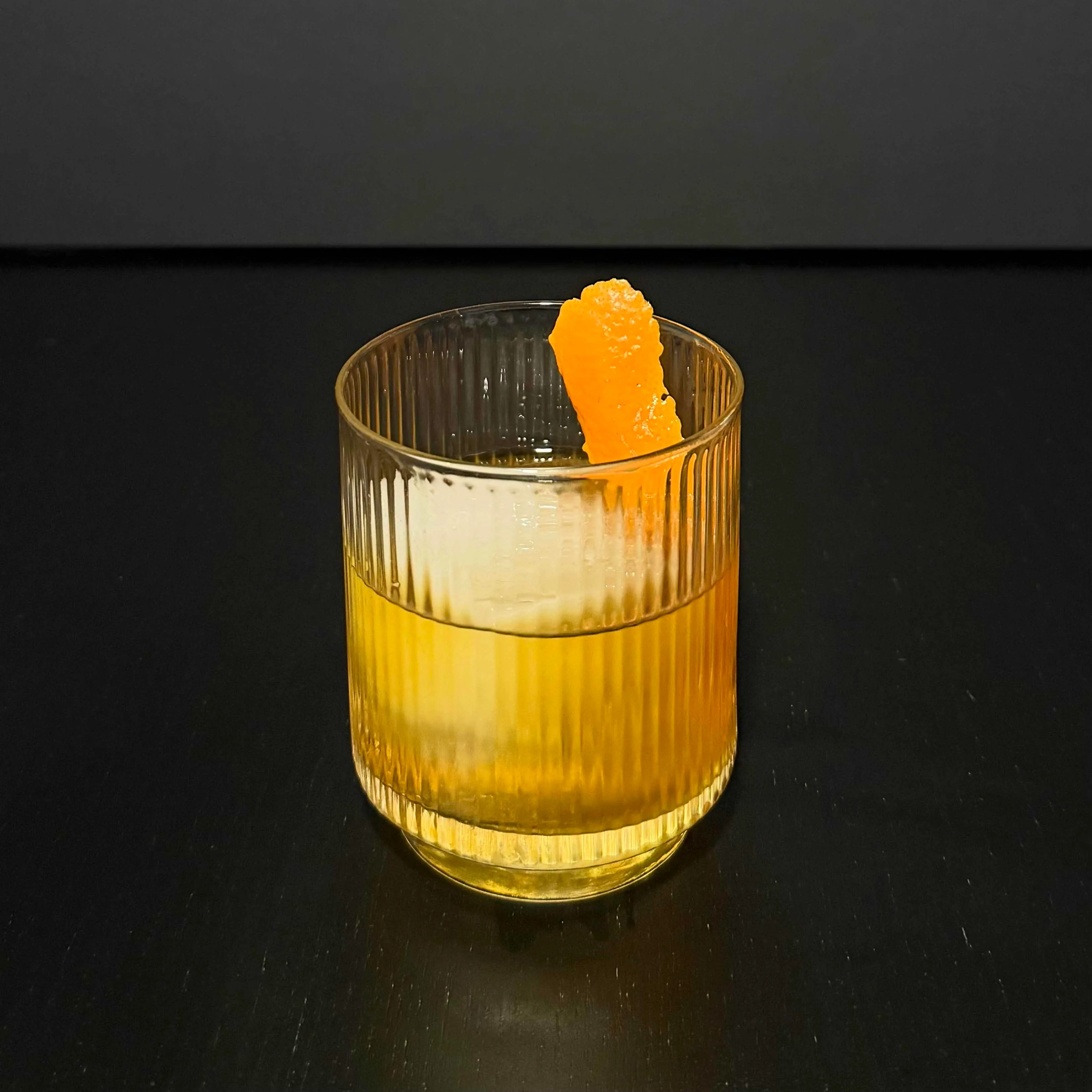 Victory Fashioned in a rocks glass with an expressed orange peel — a bourbon and melon liqueur Old Fashioned riff